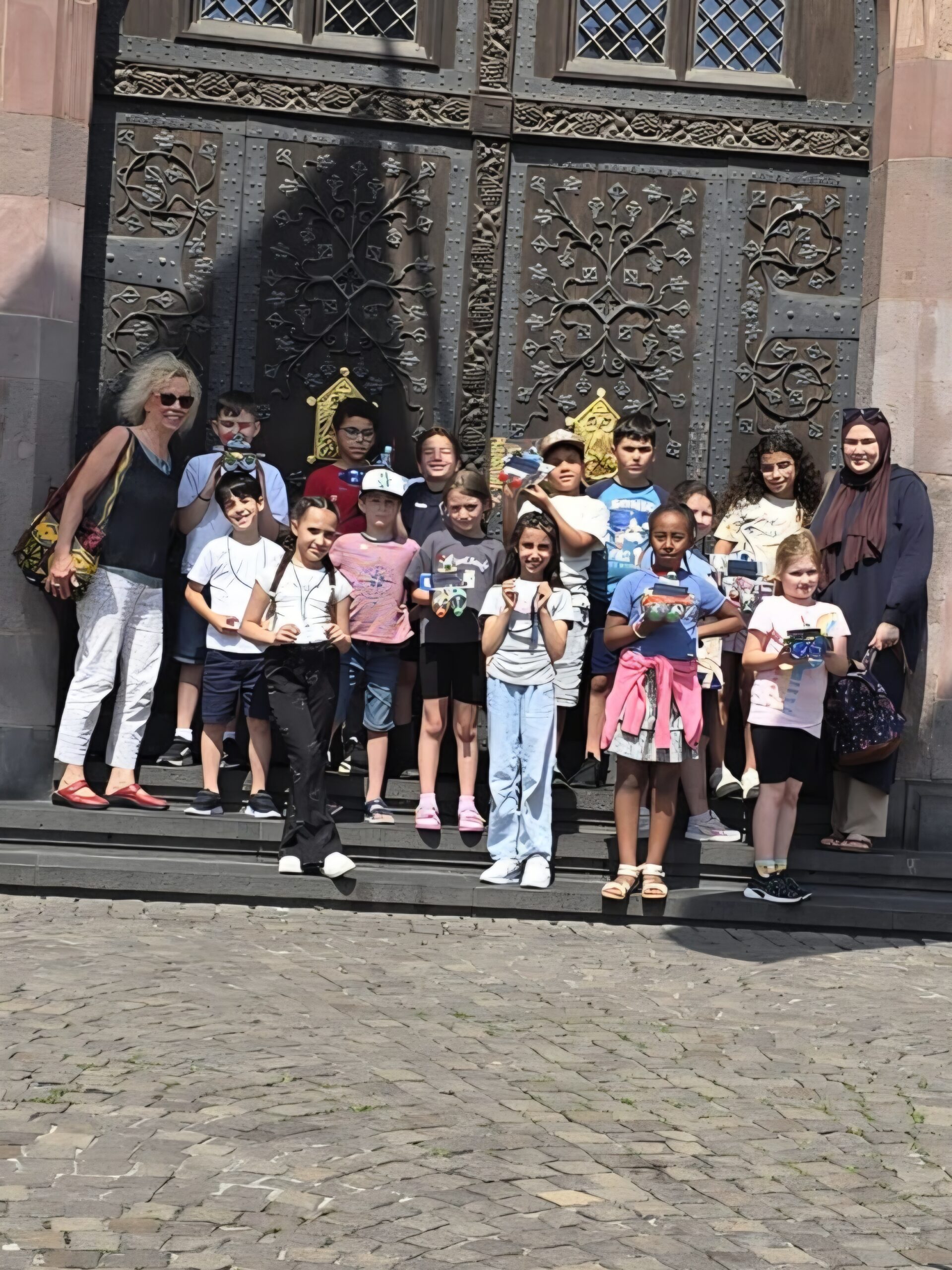IMG-20250617-WA0024 Zu sehen sind Kinder vor einer großen, alten Metalltür des Frankfurter Rathaus.